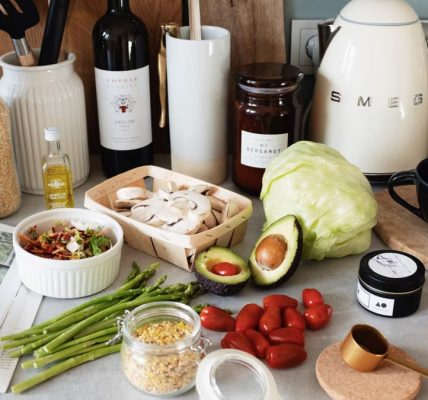 Assorted healthy food and vegetables set locating on gray countertop next to various utensils and appliances during cooking in stylish kitchen