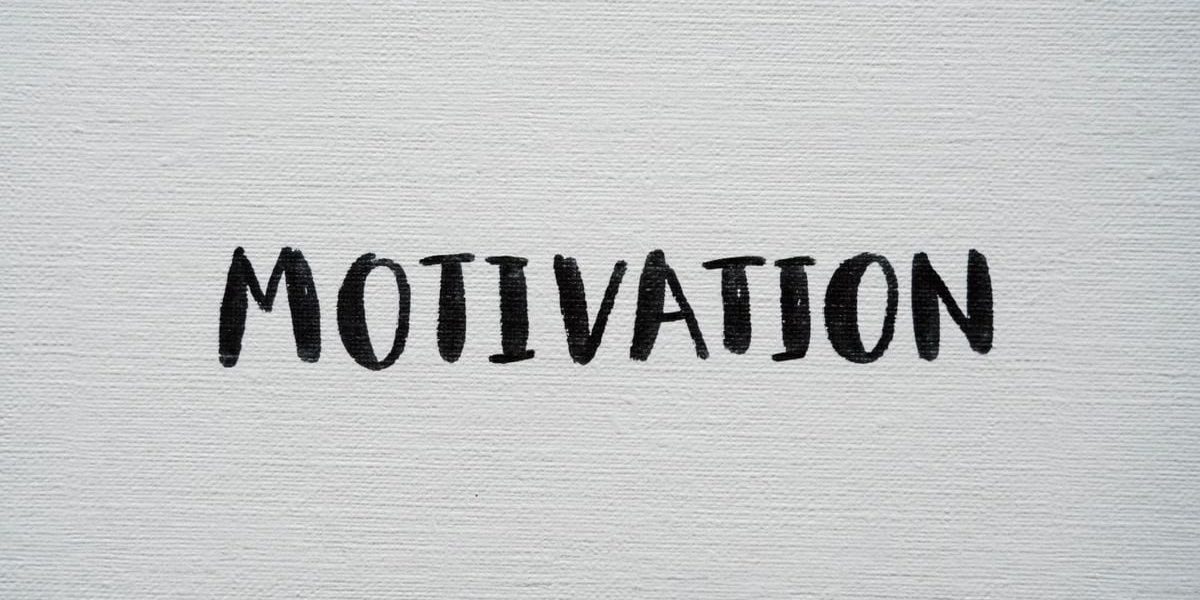 Inspirational word 'Motivation' in black on a white textured canvas background.