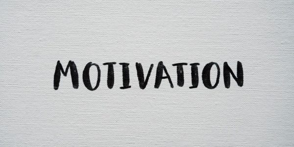Inspirational word 'Motivation' in black on a white textured canvas background.